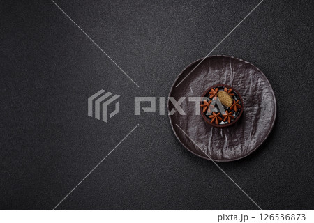 Sweet round tart with chocolate coating and nut filling 126536873