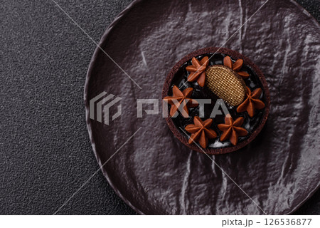 Sweet round tart with chocolate coating and nut filling 126536877