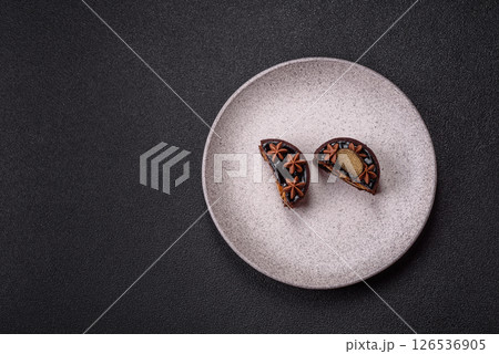 Sweet round tart with chocolate coating and nut filling 126536905