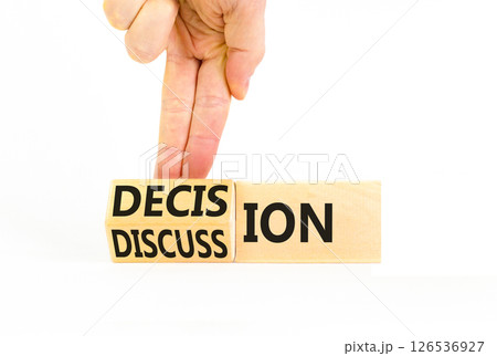 Discussion and decision symbol. Concept word Discussion and Decision on wooden cubes. Businessman hand. Beautiful white table white background. Business discussion and decision concept. Copy space. Discussion and decision symbol. Concept word Discussion and Decision on wooden cubes. Businessman hand. Beautiful white table white background. Business discussion and decision concept. Copy space. 126536927