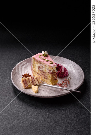 A piece of pink layered cake with strawberry flavor 126537022