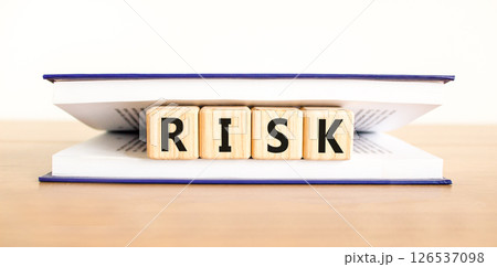 Risk symbol. Concept word Risk on beautiful wooden blocks in book. Beautiful wooden table white background. Business, lifestyle, support and risk concept. Copy space. 126537098
