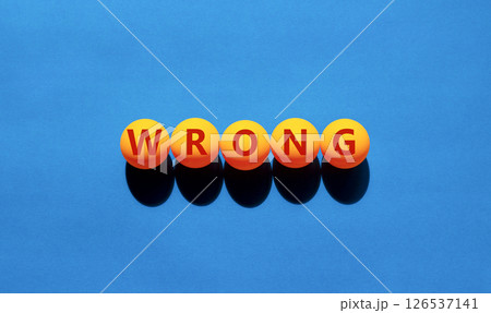 Wrong symbol. Concept word Wrong on beautiful yellow tennis ping pong balls. Beautiful wooden table wooden background. Business lifestyle wrong concept. Copy space. 126537141
