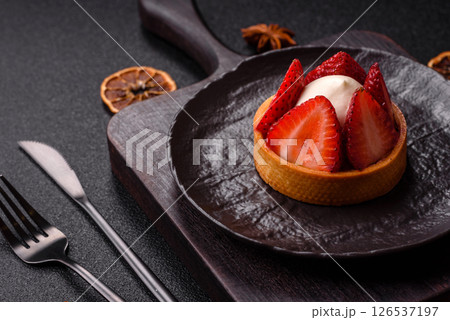 Round sweet tart with strawberry pieces and cream 126537197