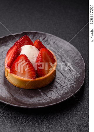Round sweet tart with strawberry pieces and cream Round sweet tart with strawberry pieces and cream 126537204