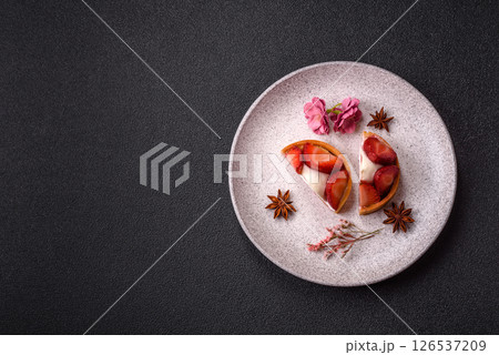Round sweet tart with strawberry pieces and cream 126537209