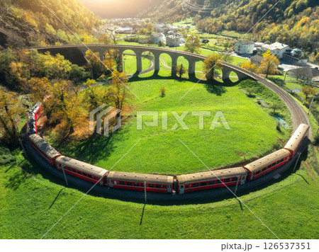 Aerial view of red train on Kreisviadukt Brusio in mountains 126537351