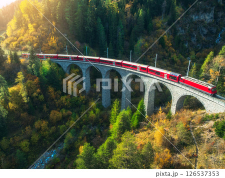Aerial view of red train on Landwasser viaduct in autumn in Alps Aerial view of red train on Landwasser viaduct in autumn in Alps 126537353