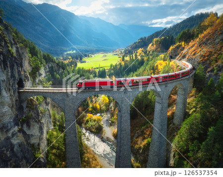 Aerial view of red train on Landwasser viaduct in autumn in Alps Aerial view of red train on Landwasser viaduct in autumn in Alps 126537354