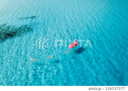 Aerial view of Inflatable pink flamingo with people on blue sea 126537377
