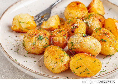 half-eaten fried new potatoes, with butter and dill, on a white plate, with a fork, at home, no people, 126537415