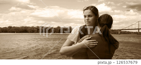 Insincere smile of a hugging girl 126537679