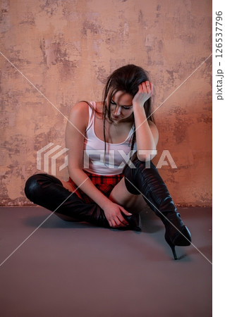 Contemplative Model in Fashion Pose Featuring Chic and Stylish Boots for a Striking Look 126537796