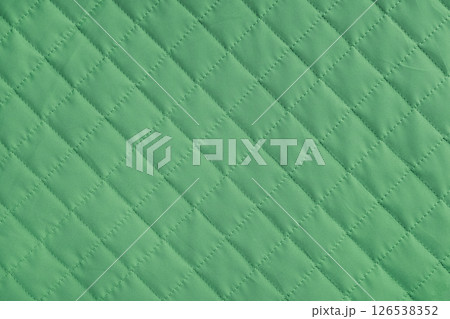 Checkered, diamond stitching pattern, green quilted fabric background. Blanket stitch texture Checkered, diamond stitching pattern, green quilted fabric background. Blanket stitch texture 126538352