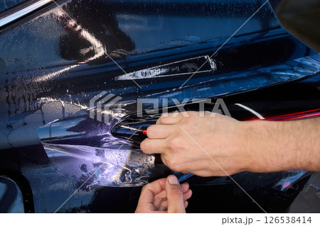 Applying a Protective Film on the Surface of Your Car for Enhanced Durability and Shine Applying a Protective Film on the Surface of Your Car for Enhanced Durability and Shine 126538414