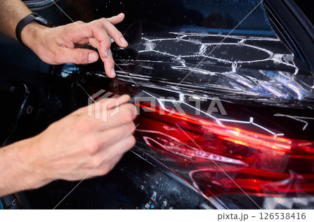 Applying a Protective Film on the Surface of Your Car for Enhanced Durability and Shine Applying a Protective Film on the Surface of Your Car for Enhanced Durability and Shine 126538416