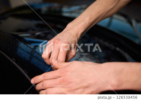 The Professional Windshield Tinting Process Conducted in a Modern Auto Showroom Environment The Professional Windshield Tinting Process Conducted in a Modern Auto Showroom Environment 126538456