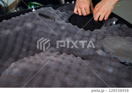 Hands Skillfully Engaged in the Construction of an Acoustic Foam Structure and Installation Hands Skillfully Engaged in the Construction of an Acoustic Foam Structure and Installation 126538458