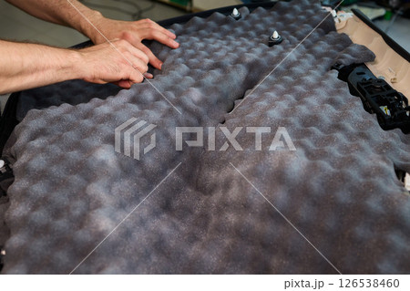 Hands Skillfully Engaged in the Construction of an Acoustic Foam Structure and Installation 126538460