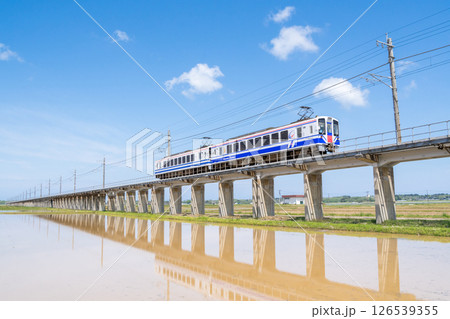 【ほくほく線】水田広がる高架区間を通過する普通列車 126539355
