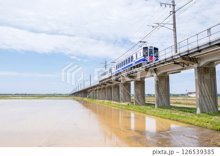【ほくほく線】水田広がる高架区間を通過する普通列車 126539385