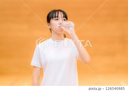 体育館でペットボトルの水で水分補給するジャージ姿の小学生,中学生,高校生の女の子 体育館でペットボトルの水で水分補給するジャージ姿の小学生,中学生,高校生の女の子 126540985
