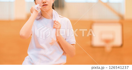 体育館でタオルで汗を拭く体操着姿の小学生,中学生,高校生の女の子 126541237
