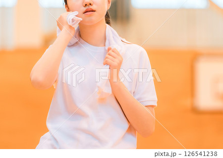 体育館でタオルで汗を拭く体操着姿の小学生,中学生,高校生の女の子 126541238