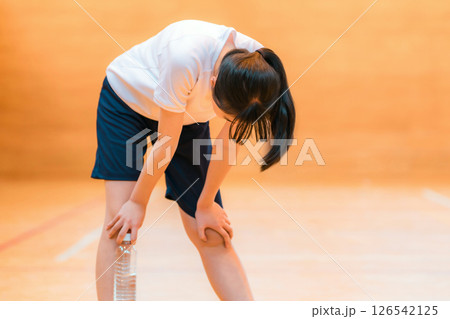 体育館にいるハードトレーニングで疲れている体操着姿の小学生,中学生,高校生の女の子 126542125
