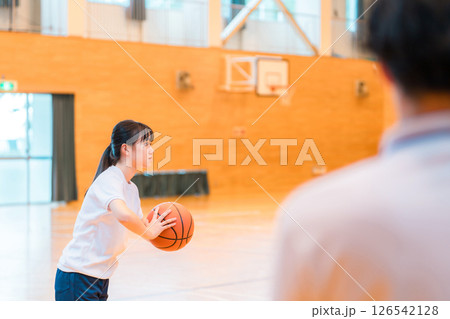 体育館でバスケットボールを持つ体操着姿の女子中学生・女子高生と男性教師 126542128