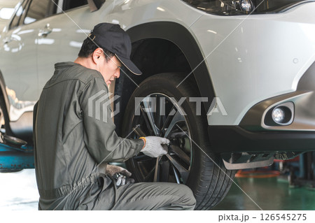 リフトアップした車のタイヤ交換をする整備士の男性 リフトアップした車のタイヤ交換をする整備士の男性 126545275