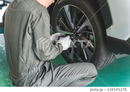 リフトアップした車のタイヤ交換をする整備士の男性 126545276