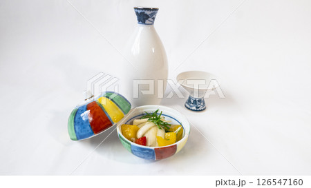 日本酒の徳利とおちょことカラフルな蓋つきの食器に盛られたラッキョウとカラーピーマンのマリネの写真 日本酒の徳利とおちょことカラフルな蓋つきの食器に盛られたラッキョウとカラーピーマンのマリネの写真 126547160