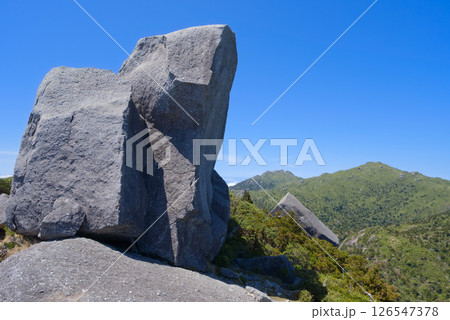 屋久島、黒味岳山頂の岩塊と永田岳、宮之浦岳 126547378