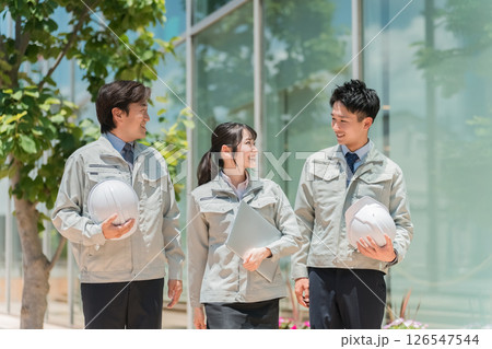 屋外を歩く作業着,作業服姿の建設業,建築業の男女スタッフ 126547544