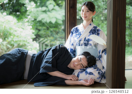 緑が美しい縁側で膝枕でくつろぐ浴衣の男性と美しい女性 旅行や旅館などの湯上り温泉のイメージ 緑が美しい縁側で膝枕でくつろぐ浴衣の男性と美しい女性 旅行や旅館などの湯上り温泉のイメージ 126548512