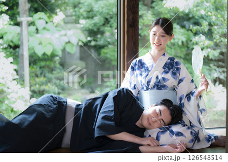 緑が美しい縁側で膝枕でくつろぐ浴衣の男性と美しい女性 旅行や旅館などの湯上り温泉のイメージ 緑が美しい縁側で膝枕でくつろぐ浴衣の男性と美しい女性 旅行や旅館などの湯上り温泉のイメージ 126548514
