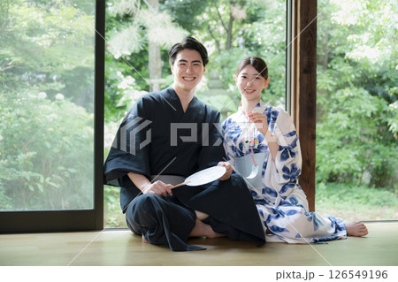 緑が美しい縁側でくつろぐ浴衣の男性と美しい女性　旅行や旅館などの湯上り温泉のイメージ　カメラ目線 126549196