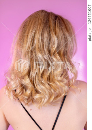 An elegantly captivating portrait showcasing stunning blonde curly hair from the back side An elegantly captivating portrait showcasing stunning blonde curly hair from the back side 126551007