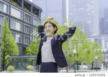 屋外でストレッチをする若いビジネスウーマン 126552009