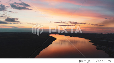 sunset with clouds, light rays over river with reflections 126554029