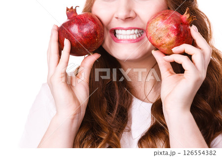 Cheerful woman holds pomegranate fruits, isolated Cheerful woman holds pomegranate fruits, isolated 126554382