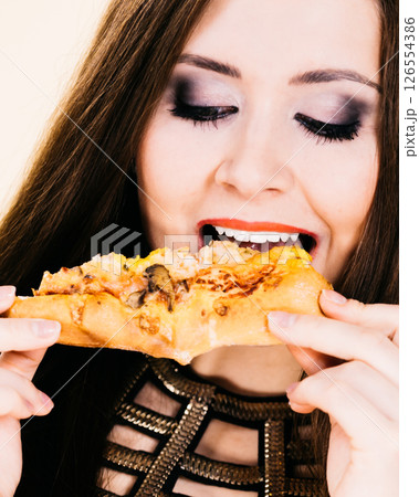 Woman eating hot pizza slice 126554386