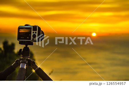 Camera taking picture film of sunrise over sea surface Camera taking picture film of sunrise over sea surface 126554957