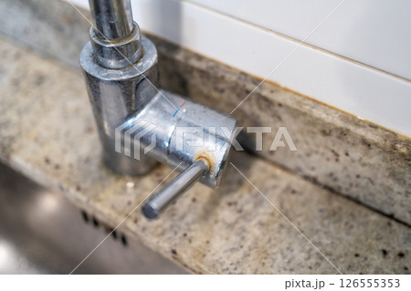 Dirty kitchen sink faucet contaminated with calcium and dirt. Dirty kitchen sink faucet contaminated with calcium and dirt. 126555353