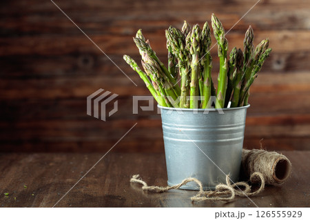 Fresh asparagus in small bucket on a old wooden table. 126555929