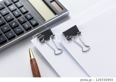 クリップで挟んだ資料と電卓 126556993
