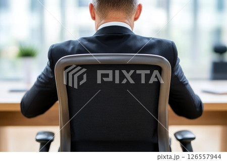 Business Executive Seated at Office Desk from Behind Business Executive Seated at Office Desk from Behind 126557944