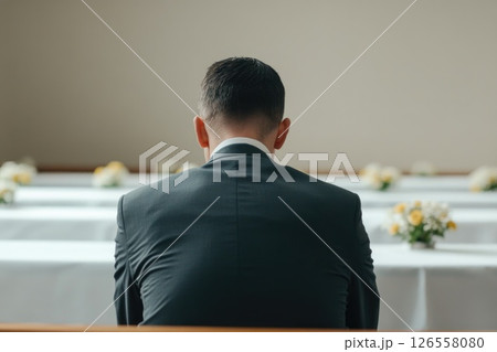 Man Sitting Alone in Quiet Funeral Service 126558080