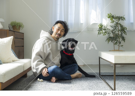 愛犬とリビングでくつろぐ男性  愛犬とリビングでくつろぐ男性  126559589
